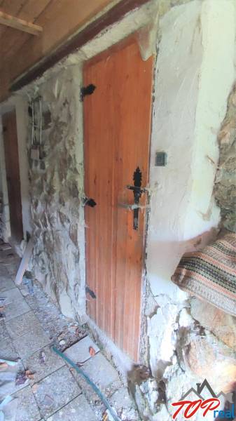Wooden door in a stone wall in the Cottage in Ružín, Malá Lodina.