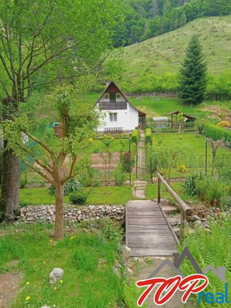 A cottage in Malá Lodina on Ružín Street with a landscaped garden in a natural setting.