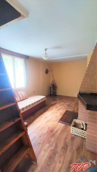 The interior of the cabin with wooden stairs, flooring, and a fireplace creates a cozy atmosphere.