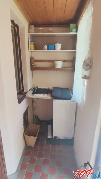 Interior of a cabin with a small kitchenette, shelves, and storage space.