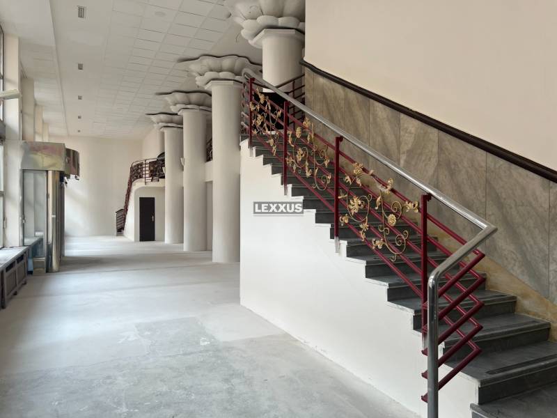 Interior of commercial premises with a spiral staircase and decorative columns.