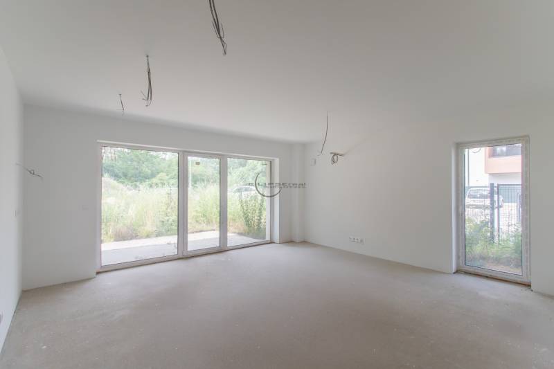 Bright empty room with large windows in a 2-room apartment.