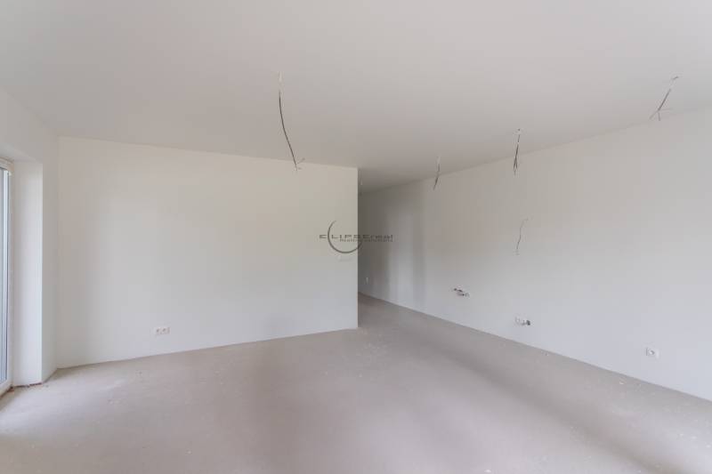 A spacious room with white walls and lighting preparation in a 2-room apartment.
