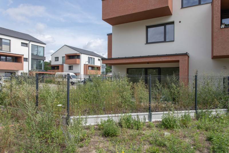 The exterior of the apartment complex on Javorová Street in Kostolište with a fence and greenery.