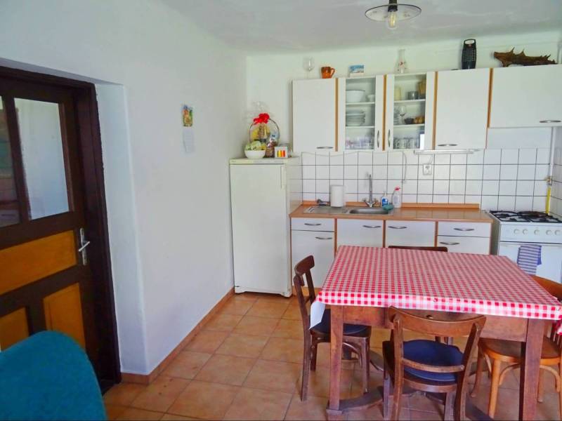 A kitchen in a family house with a table and a checkered tablecloth, a simple and cozy space.