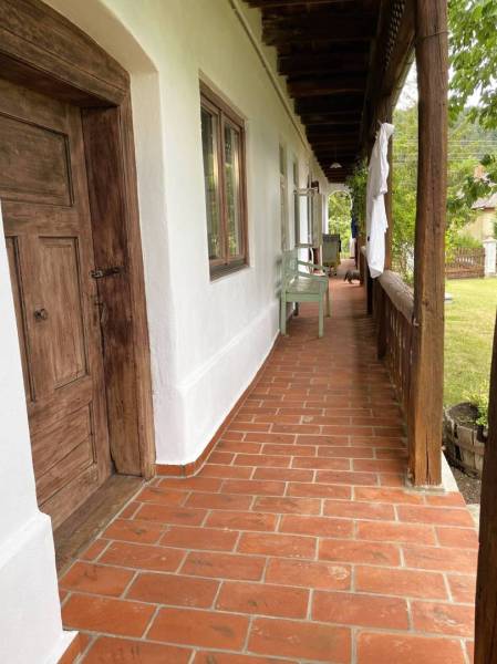 Traditional porch of a family house in Pányok with wooden doors and tiles.
