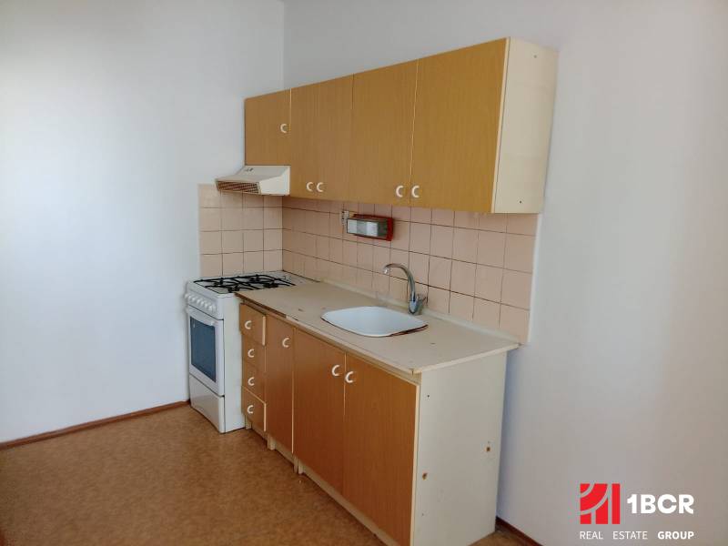 A kitchen unit with a stove and a range hood in a 3-room apartment.