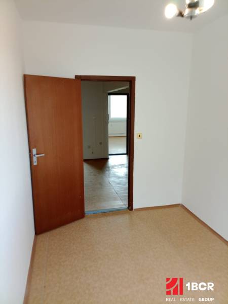 A room in a 3-room apartment with open doors, the floor covered with light linoleum.