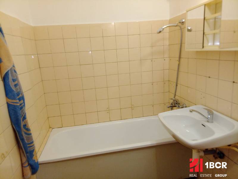 Bathroom in a 3-room apartment with a bathtub, sink, and tiles.