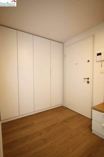 Entrance hall in a 2-room apartment with cabinets and wooden flooring.