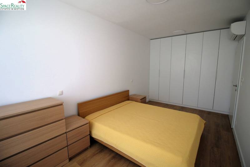 Bedroom in a 2-room apartment with a double bed and a large built-in wardrobe.