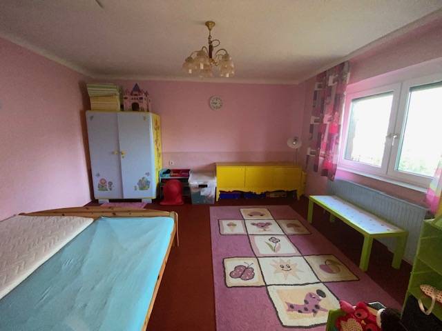 A children's room in a family house with pink walls and a play mat.