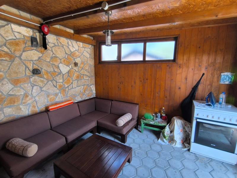 Stone wall and wooden interior with a sofa in a 2-room apartment.
