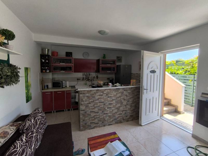 Living room and kitchen in a 2-room apartment with entrance and view into the courtyard.