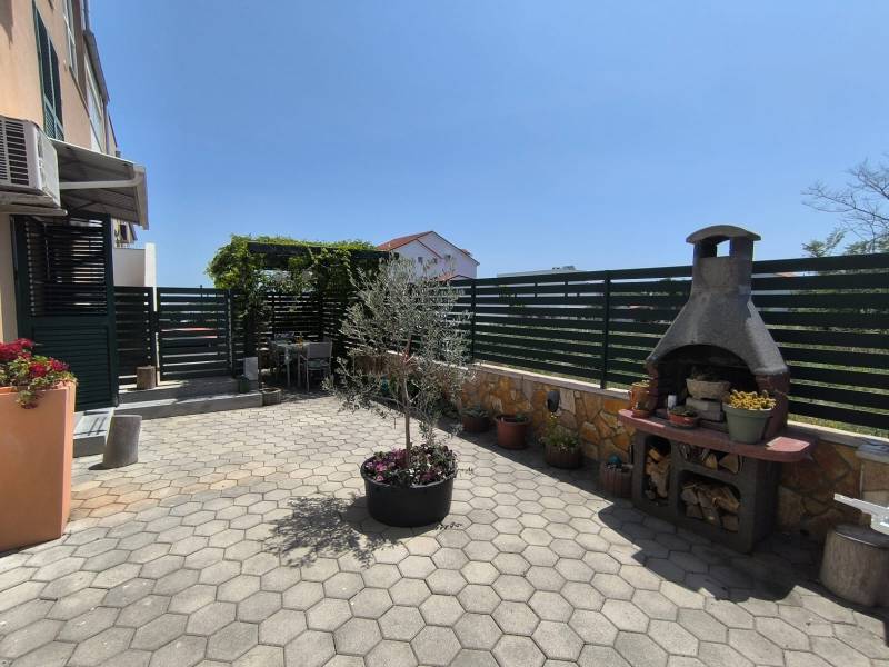 There is a terrace with a grill and flowers in the exterior of the 2-room apartment in Nitra.