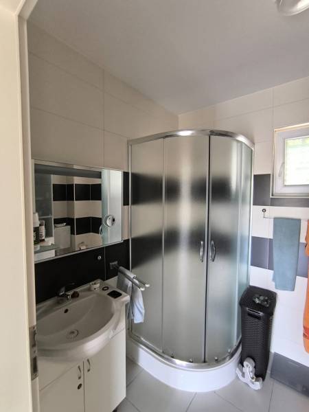 Bathroom with a shower and a sink in a 2-room apartment.