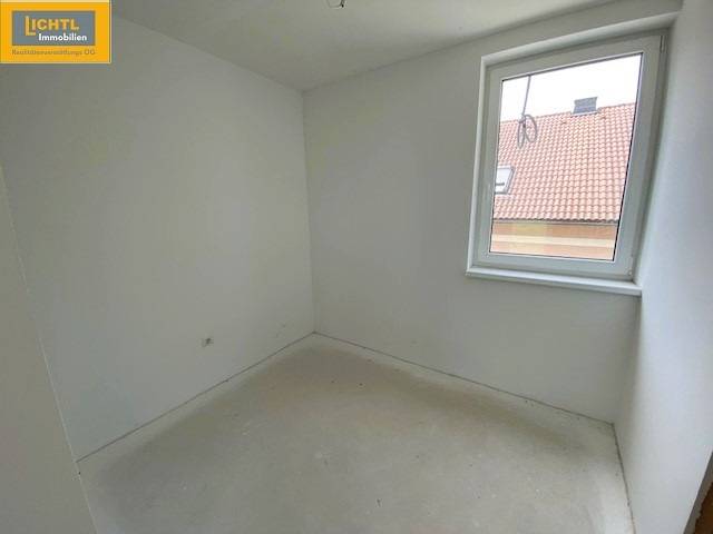 Empty room in a 5 or more bedroom apartment with white walls and a window.