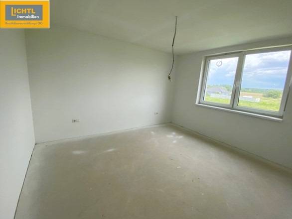 A view into an empty room with a window, part of a 5 or more room apartment.