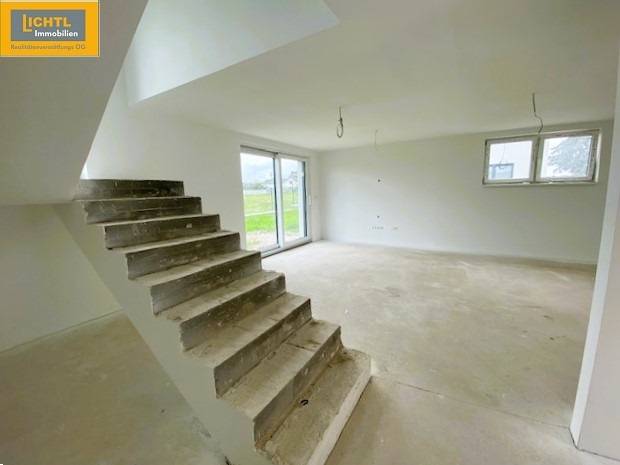 Interior of a 5 or more bedroom apartment with a concrete staircase and spacious living area.