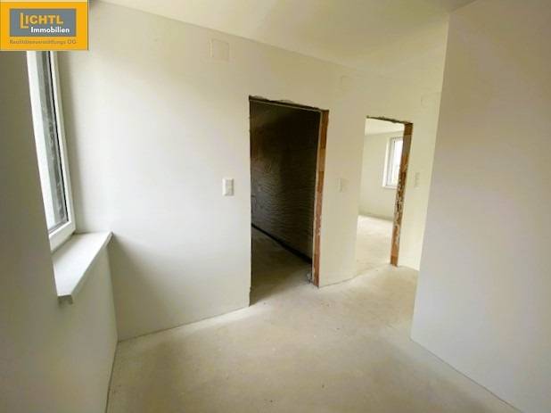 Interior of a 5 or more room apartment with white walls and windows, awaiting completion.