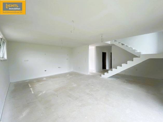 A spacious staircase in a 5 or more room apartment with white walls and an open space.