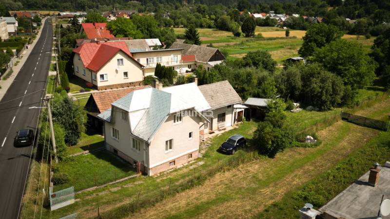 A family house in Konská surrounded by greenery with an adjacent long street.
