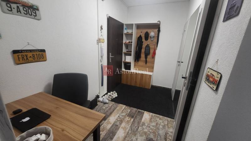 Entrance hall in a one-room apartment with wooden furniture and license plates.