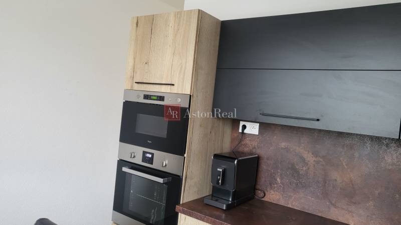 A kitchen unit with an oven and a coffee maker in a studio apartment.
