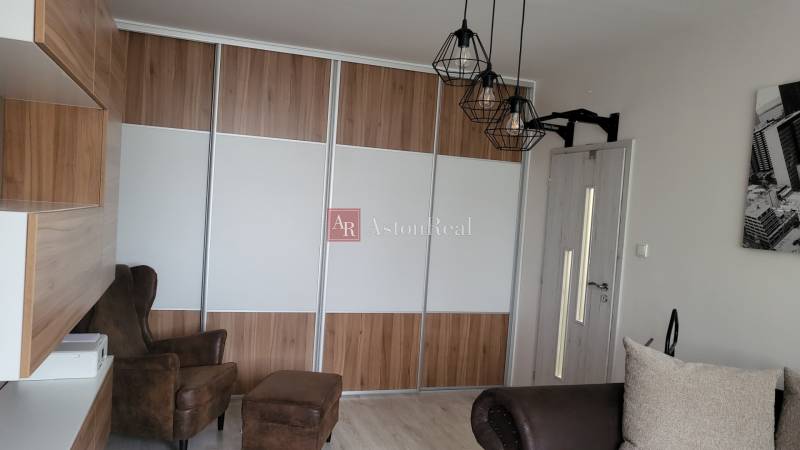 A wardrobe and an armchair in a studio apartment, a cozy space for relaxation.