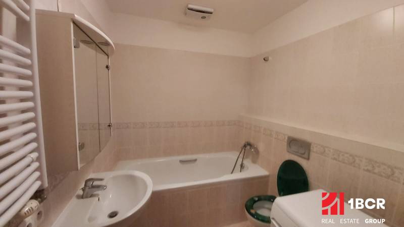 A bathroom with a bathtub, a mirrored cabinet, and a sink in a 2-room apartment.