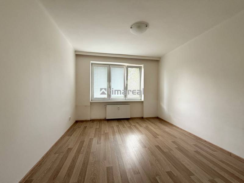 An empty room with a wooden floor and a window in a two-room apartment.