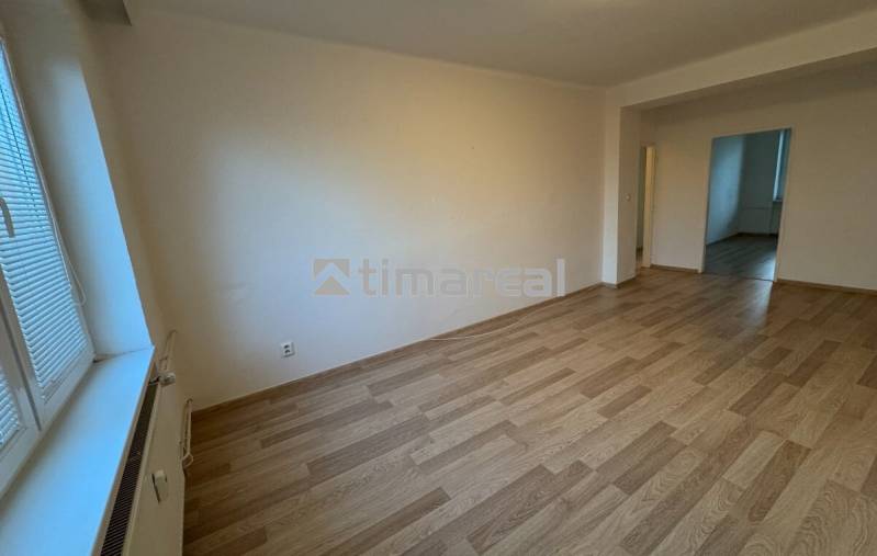 Interior of a 2-room apartment with wooden flooring and white walls.