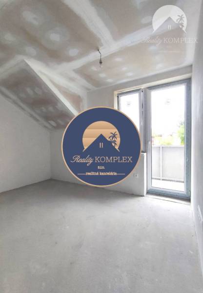 An interior in a family house with unfinished walls and large windows, without furniture.