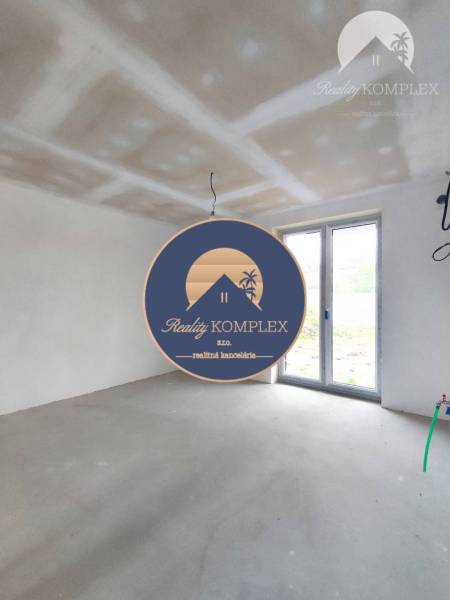Empty room in a family house with white walls and large windows.