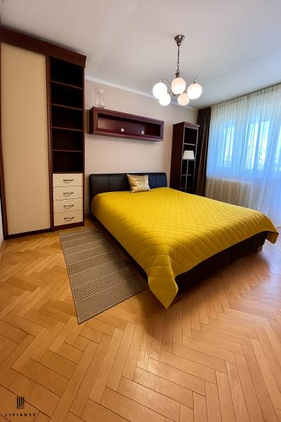 Bedroom with a double bed and a yellow blanket in a two-room apartment.