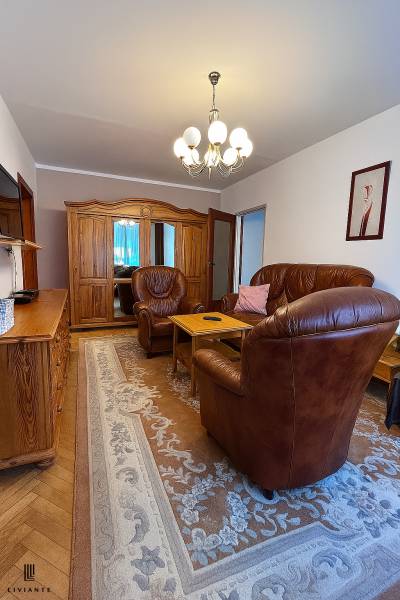 Leather armchairs and wooden furniture in the living room of a two-room apartment.