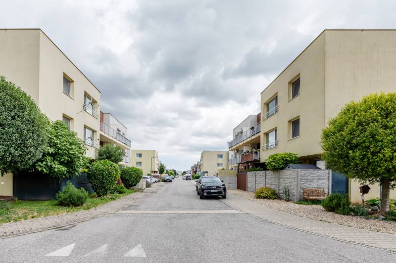 Agátová Street in Rovinka with apartment buildings and parked cars.