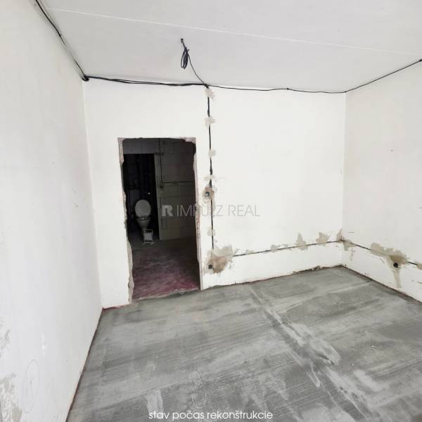 A room under renovation in a 2-room apartment with ceramic tiles and unfinished walls.