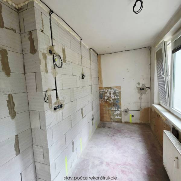 Reconstruction in a 2-room apartment, showing bare walls and electrical installation.