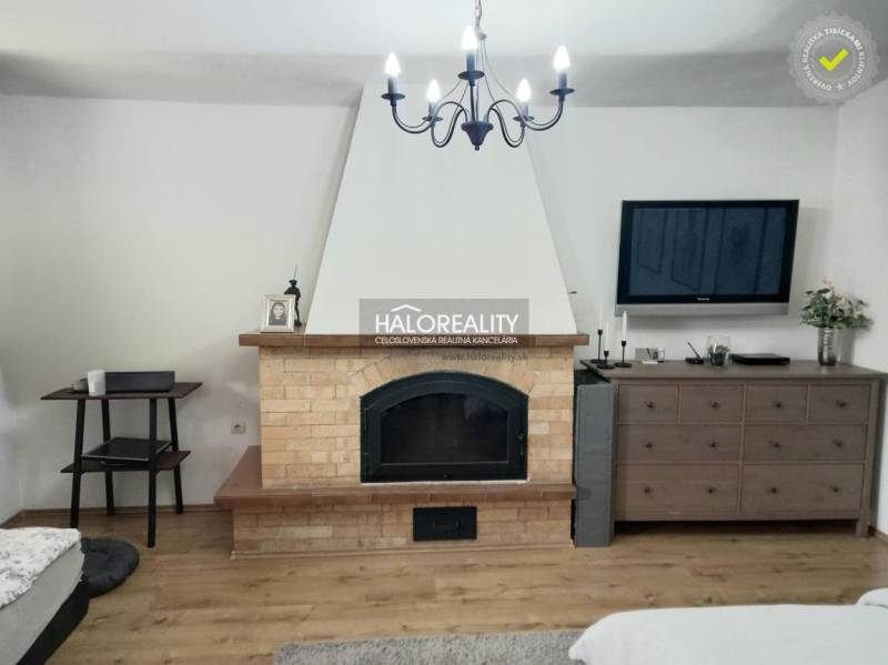 A room with a television and a dresser in a family house with wooden flooring.