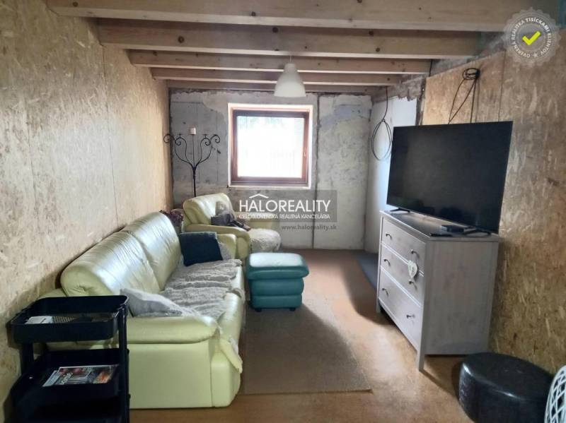 The family house offers a comfortable living room with a leather sofa and a television.