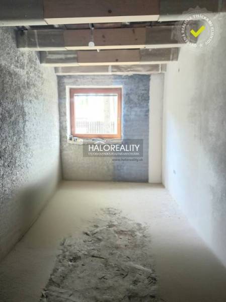 Renovation of a room in a family house with a wooden window and plastered walls.