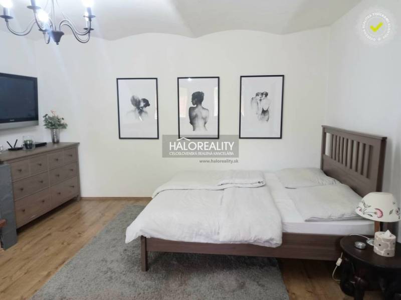A bedroom in a family house with four beds and pictures on the wall.