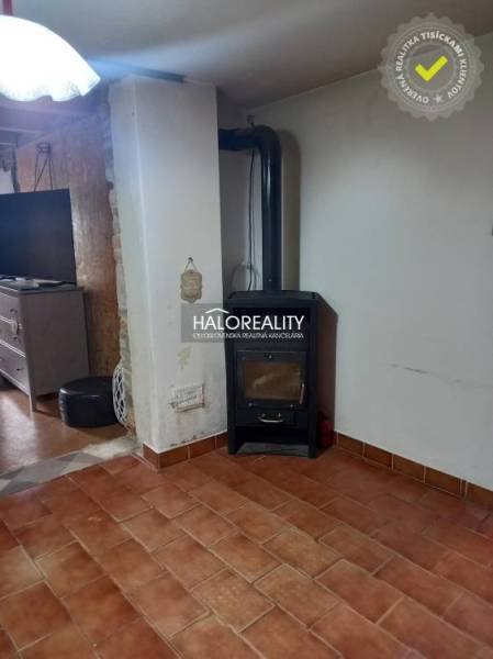 Interior of a family house with a tiled stove, light, and tiles.