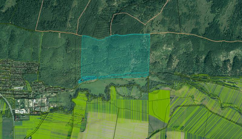 Aerial photograph of agricultural and forest land near Hranovnica, showing forests, fields, and buildings.