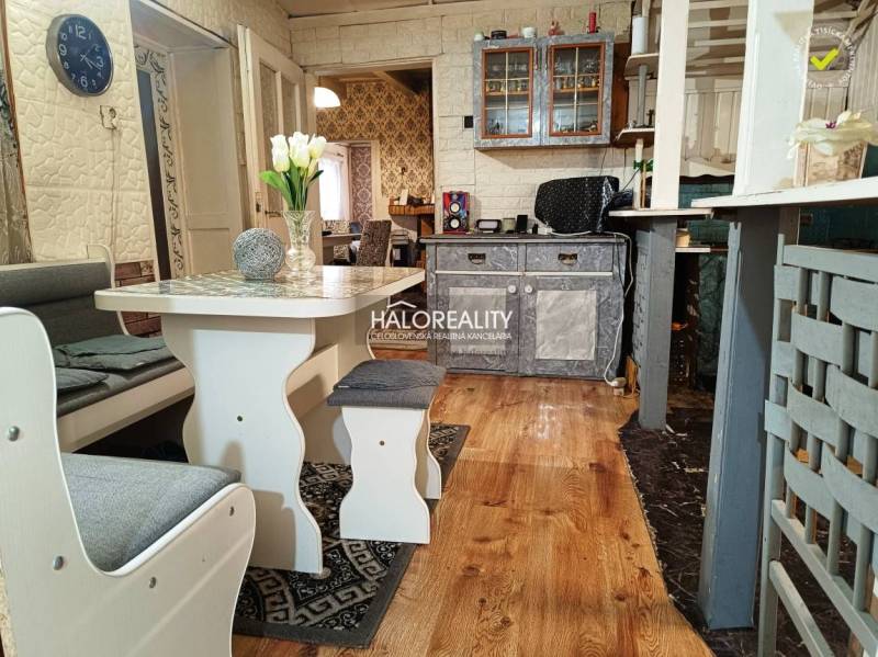 Interior of a family house with kitchen furniture, wooden floor, and dining table.