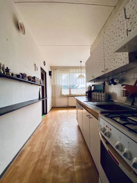 The kitchen in a 4-room apartment with a bright interior, modern stove, and wooden floor.