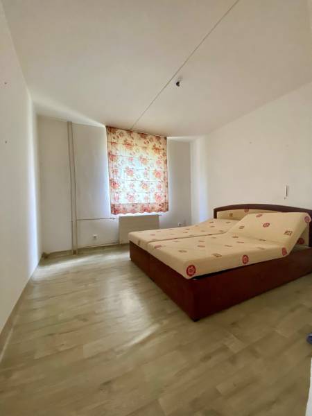 A bedroom with a bed and floral curtains in a 4-room apartment.