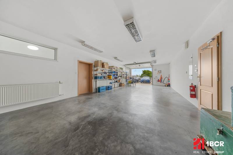 A spacious garage in a family house with shelves and open doors.