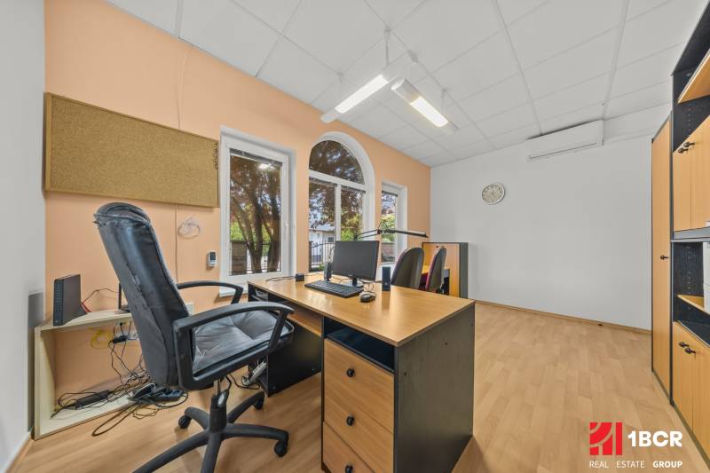 Office in a family house with a wooden desk, chair, computer, cork board.